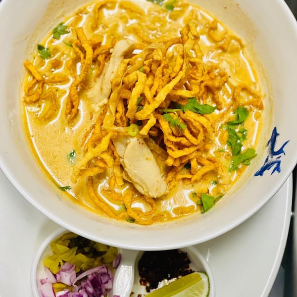 Taste Asian Fusion Bistro's Khao Soi, a creamy yellow curry noodle soup with chicken and crispy noodles.